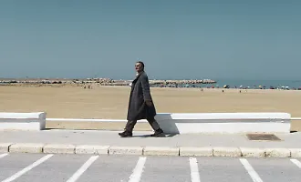 Scoglitti, l'uomo con il cappotto sul lungomare in piena estate